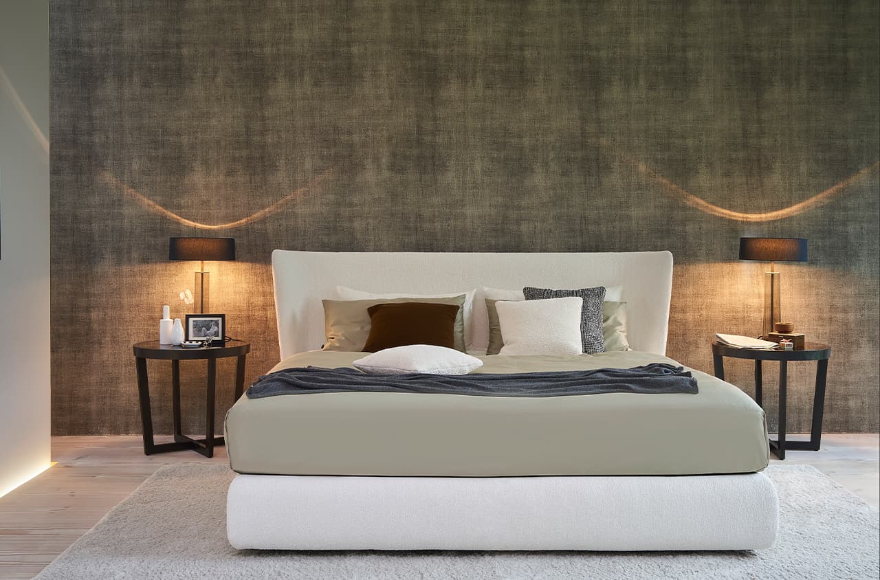 Stilvolles Schlafzimmer mit sanften Farben und einem hellen Polsterbett.